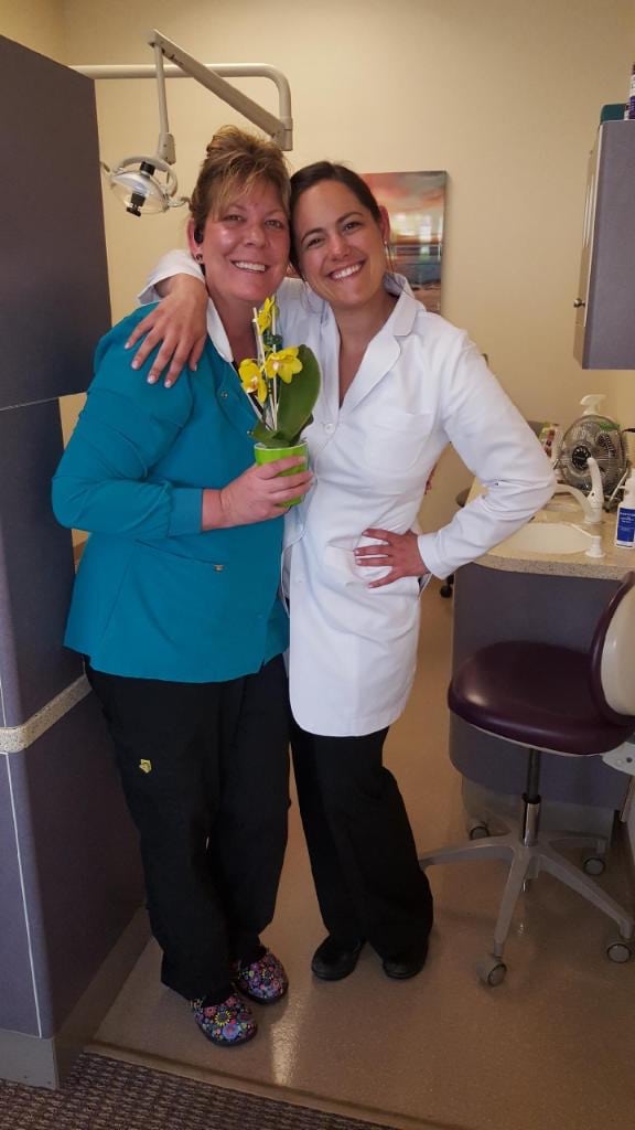 Dr. Gonzales Posing with Staff Member Holding Flowers