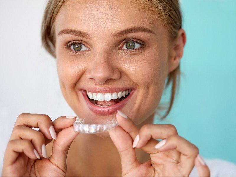 Woman Putting On Clear Retainer