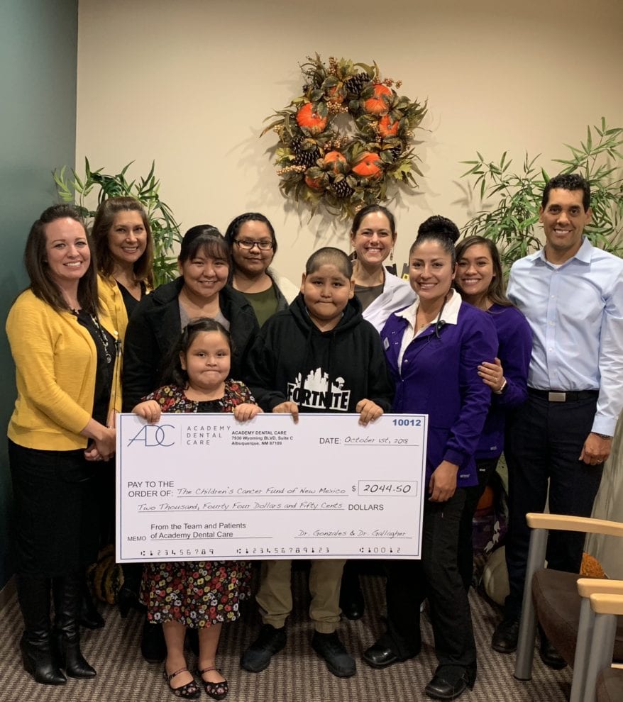 Image of Group with Two Children Holding Big Check for Children's Cancer Fund of New Mexico