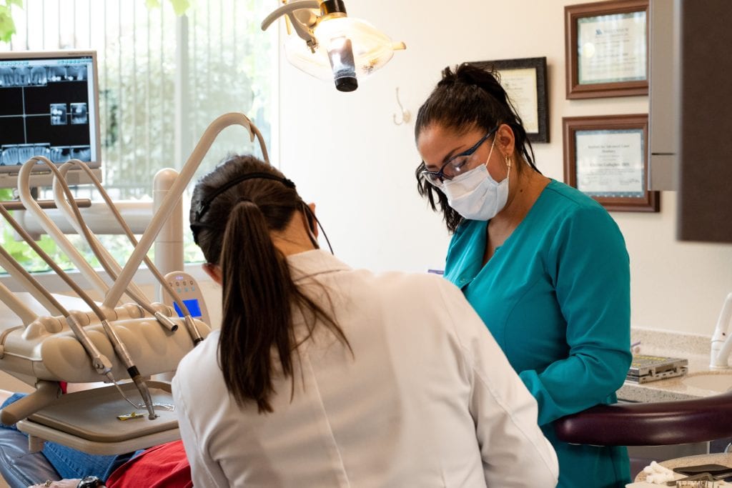 Dr. Gonzales and Assistant Working on Dental Patient