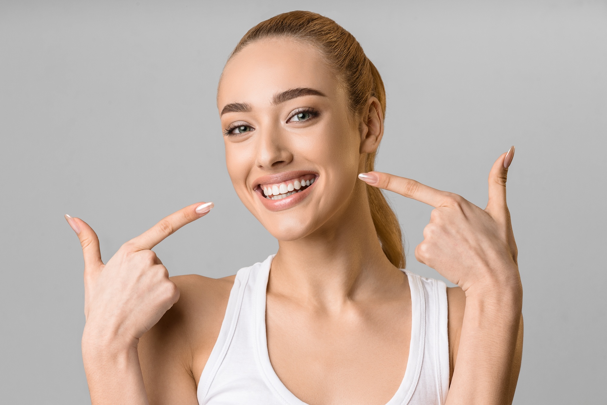 Image of a young woman smiling because of teeth whitening in Albuquerque